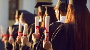 pessoas de costas formando com roupas de formatura e canudos de formatura na mão