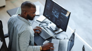 homem mexendo em computadores como um desenvolvedor de sistemas